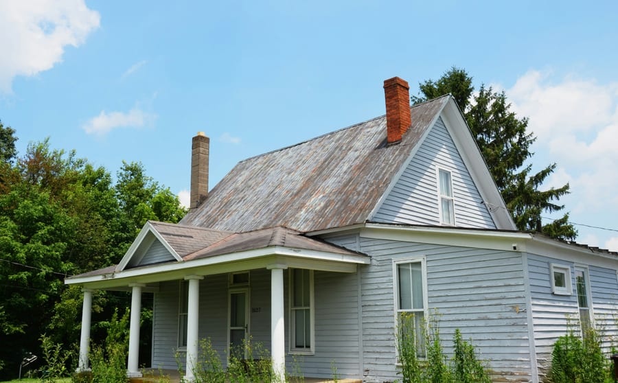 An older farmhouse with a porch and a later addition